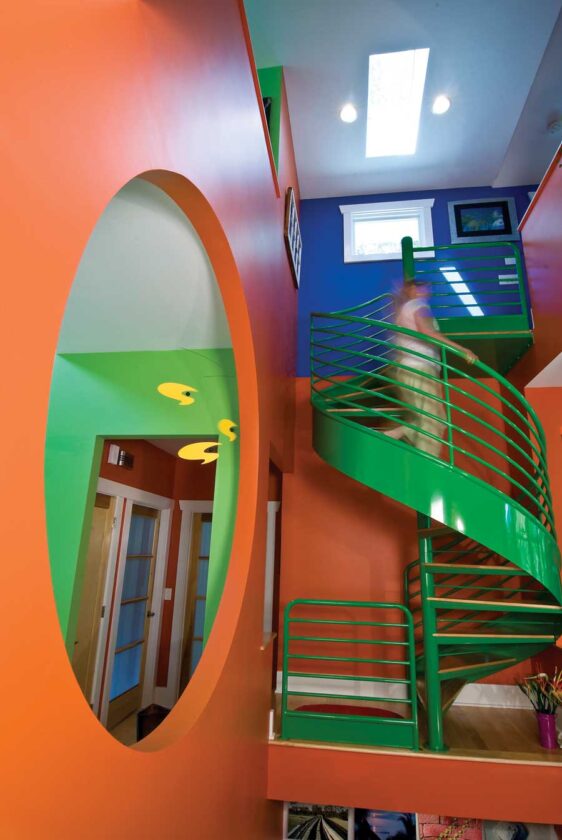 Jenny and Wes love bright, bold colors, and they worked with an interior designer to create a cheery palette. The spiral staircase that anchors the “great room”was a salvage find Jenny and Wes painted.